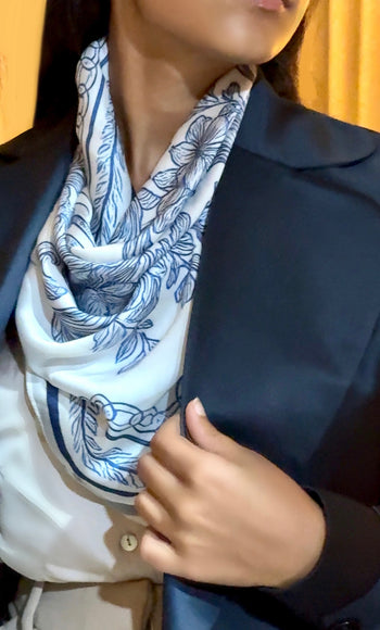 Person wearing a blue and white patterned scarf with a blurred background