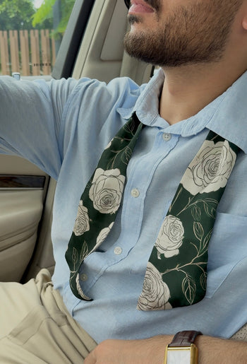 Man wearing a light blue shirt with a floral Scarf inside a vehicle