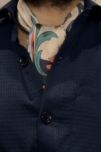 Navy blue textured coat with a patterned scarf worn by a person