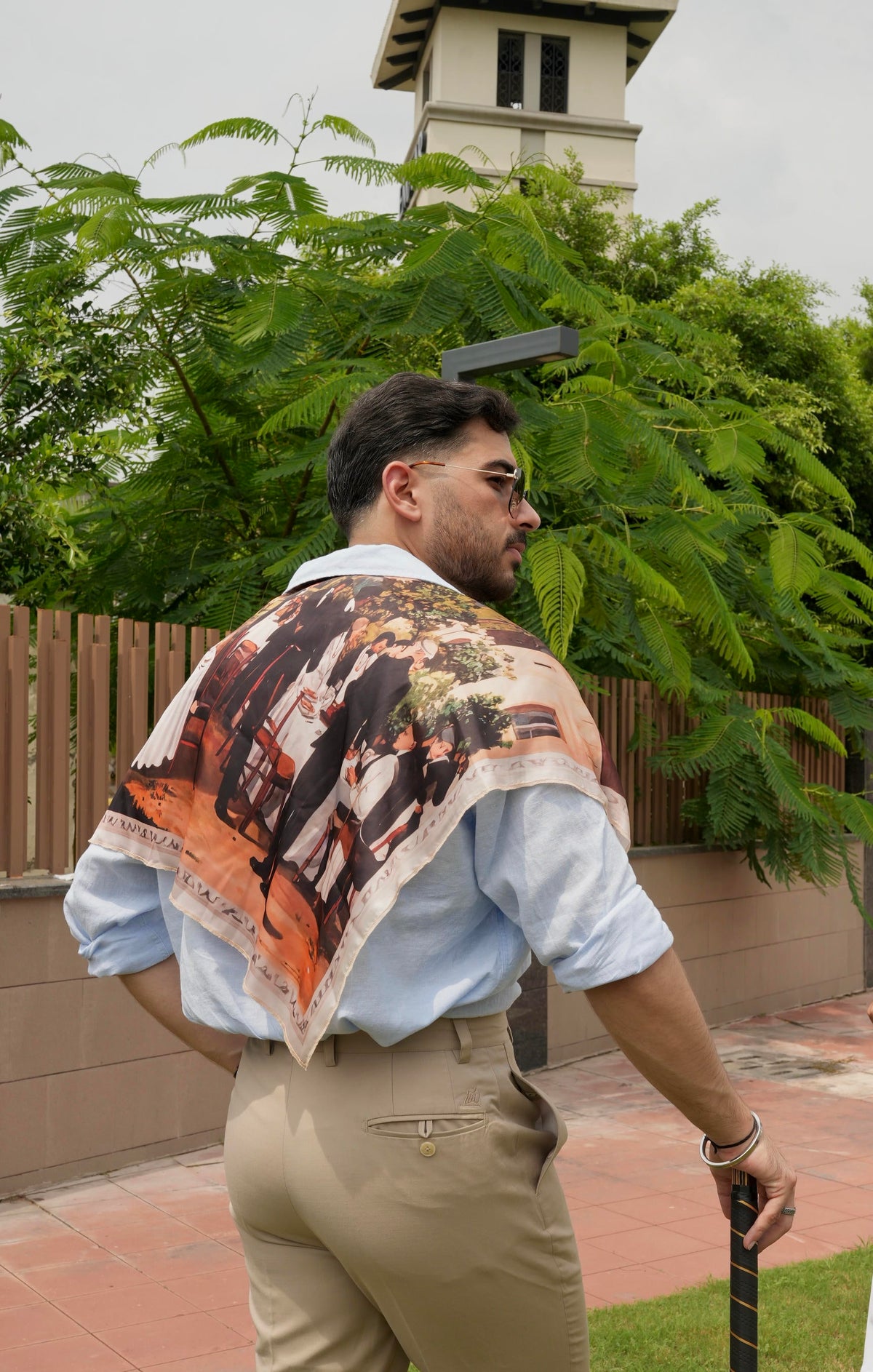 Man wearing a colorful scarf with a graphic design outdoors