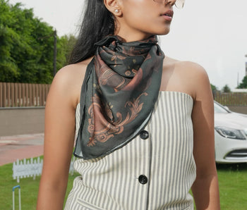 Woman wearing a patterned scarf outdoors with a blurred background